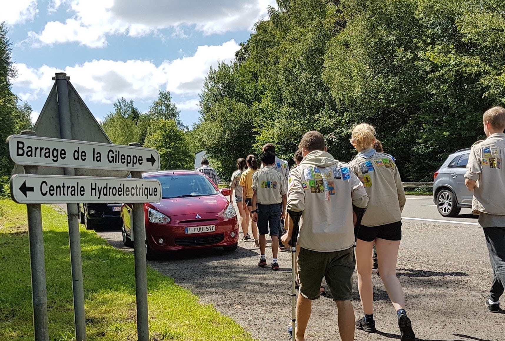 Foto van stappende givers naast auto's