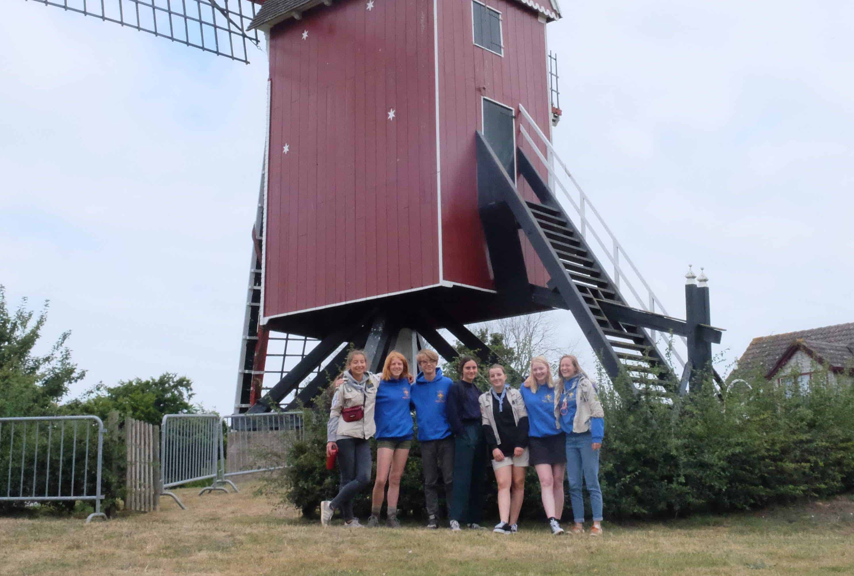 Foto van de givers op kamp voor een molen