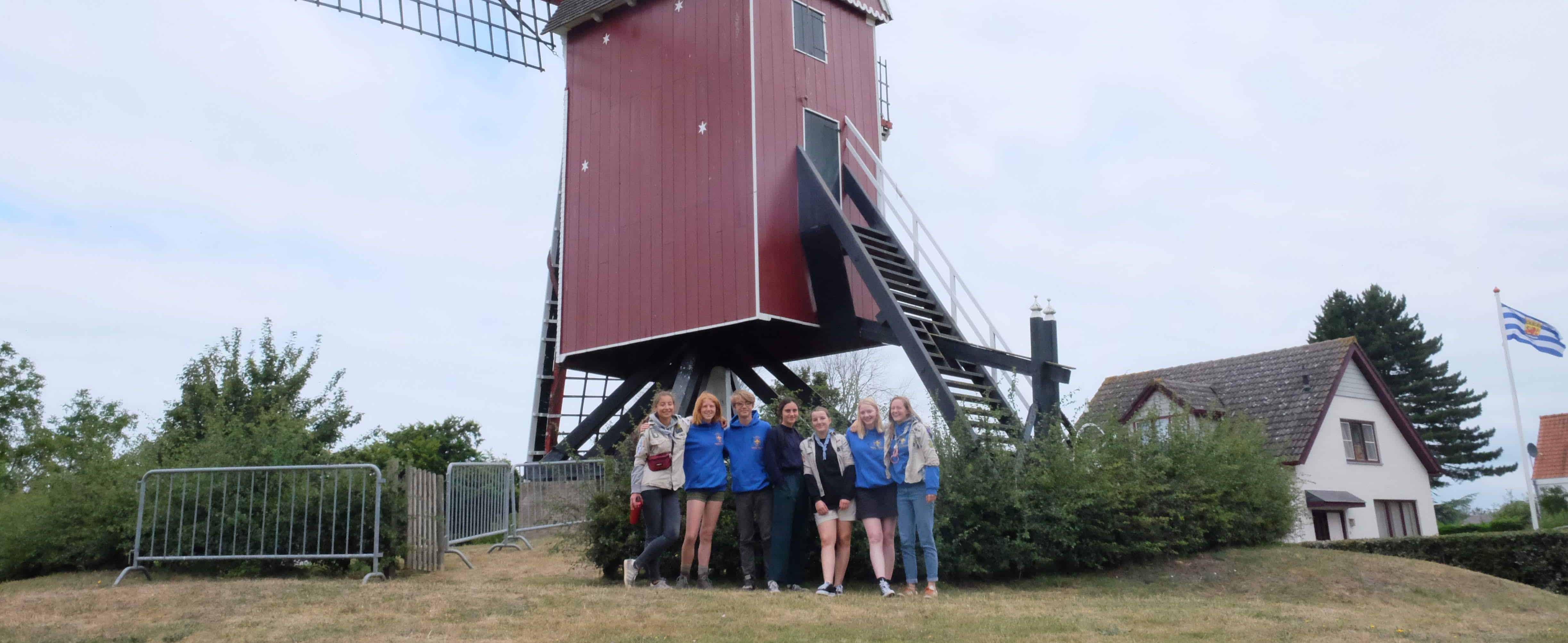 Foto van de givers op kamp voor een molen